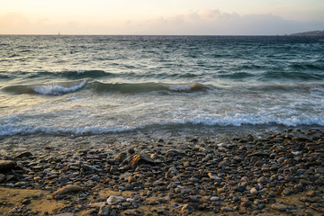 Sunset scenic copyspace wavy seaview and natural rock beach with beautiful shades of orange sky background