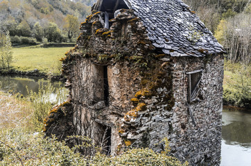 front of old ruined house on the river Aveyron Belcastel France