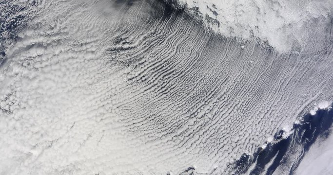 Very high-altitude overflight aerial of frozen, icy waters of the Bering Sea. Clip loops and is reversible. Elements of this image furnished by USGS/NASA Landsat