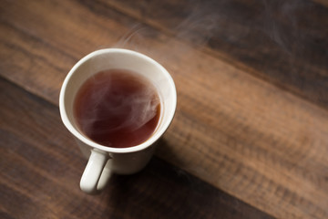 hot tea in a mug on a wooden table background.having a hot tea in morning