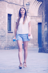Naklejka premium Woman strolling past old stone castle