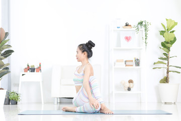 Asian beautiful sports woman performs the exercises at home .