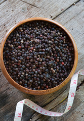 Black pepper with measuring tape on wooden table ,diet concept nutrition.