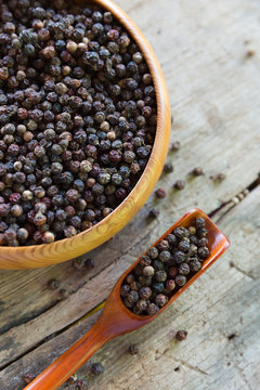 Close up black pepper seed in wooden spoon