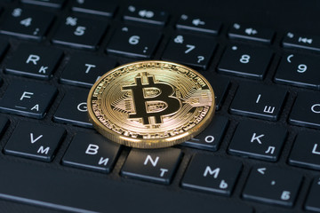 bitcoin metallic coin over black computer letters keyboard, closeup shot