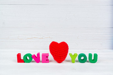 Valentine card with Love you text and red knitting heart on white wooden background and copy space for add text and picture, love and valentine day concept.