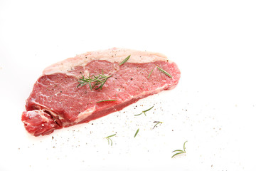 Fresh raw beef steak with pepper and rosemary isolated in white background