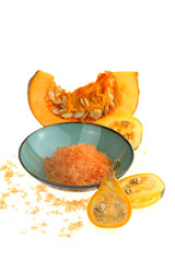 Pumpkin bath salt. Cosmetics  with pumpkin extract. Sea salt with pumpkin extract in blue cup and pumpkin in a cut on a white background