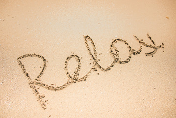 Relax word is written on the beach sand