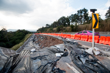 land slide on asphalt road in thailand.land slide caused by torrential rains on asphalt road in thailand. Broken road asphalt cracked