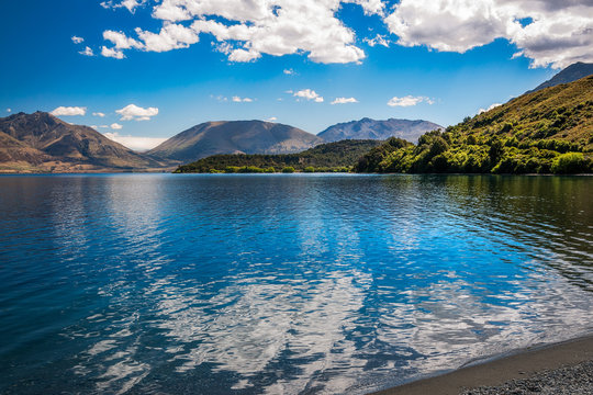 Beautiful View of Lake Wakatipu with clouds reflections in the water at Wilson Bay, Otago Region, New Zealand, Southern Island.