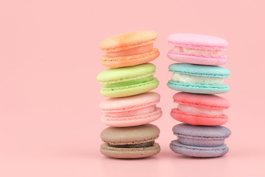 Sweet French macaroons cake (or macarons) with vintage pastel colored tone on pink background.