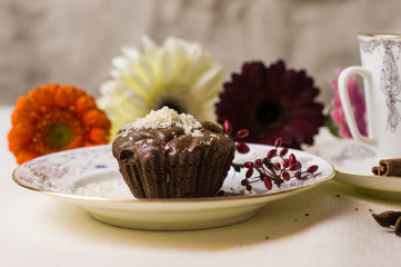 Chocolate fondant on a white plate with coffee and flowers