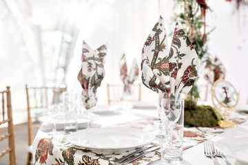 Interior of a wedding tent decoration ready for guests. Served round banquet table outdoor in marquee decorated flowers and silk. Catering concept