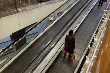 people out of focus on the escalator mall