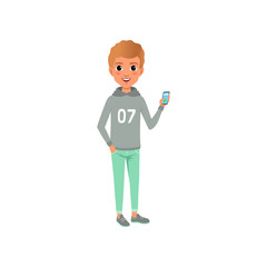 Young guy in stylish casual clothing gray hoodie with print and turquoise trousers. Cartoon boy character smiling and holding smartphone in hand. Flat vector design