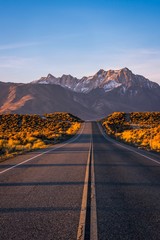 A road in Eastern Sierra leading up to a beautiful snow coverred mountain with morning light - 187429945