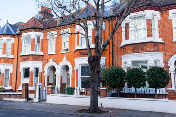 Row of restored Victorian house in red bricks and white finishing on a local street in Clapham, South London, UK - 187432353