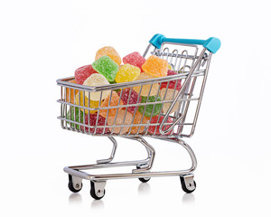 Multicolored sweets in shopping trolley.