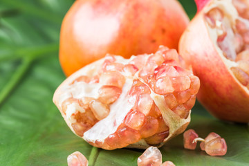 Pink juice pomegranate on leaf background