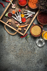 Various spices and herbs in a wooden tray.