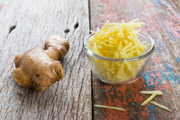 Ginger cut into strips on wooden table