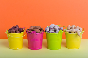 Fototapeta na wymiar Almonds, hazelnuts, pistachios, cashews in small buckets