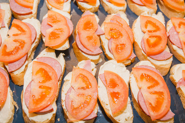 Tomato and cheese sandwich. The bread slice with tomato and cheese lies on a leaf.