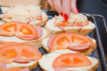 Tomato and cheese sandwich. The bread slice with tomato and cheese lies on a leaf.