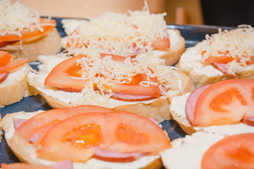 Tomato and cheese sandwich. The bread slice with tomato and cheese lies on a leaf.