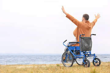 Man in wheelchair on sea shore