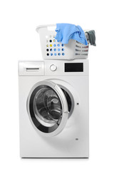 Basket with laundry on modern washing machine against white background