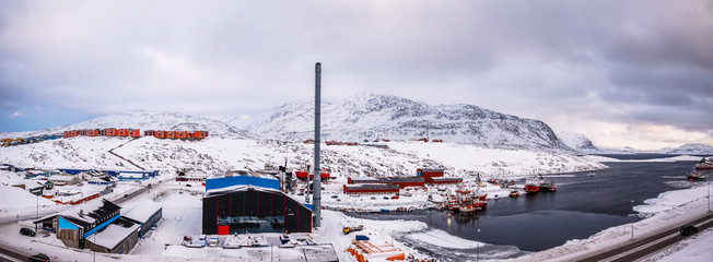 Fishing boats and harbor buildings with settlement and mountains in the background, port of Nuuk, Greenland © vadim.nefedov