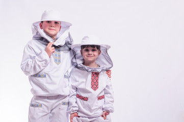 Kids in beekeeper's suits posing in studio white background.