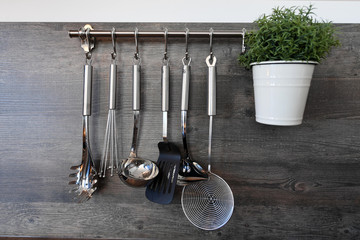 Küchenutensilien an einer Metallstange aufgehängt