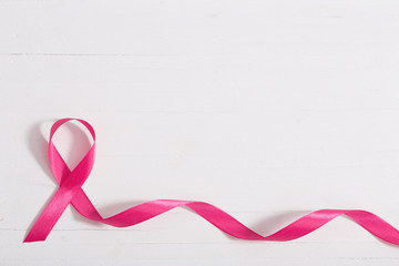 healthcare and medicine concept. pink breast cancer awareness ribbon on wooden white background