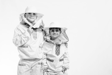 Kids in beekeeper's suits posing in studio white background.
