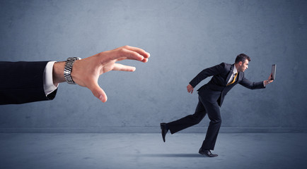Businessman running from hand