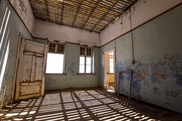 Inside view of one of the abandoned houses in the ghost town of Kolmanskop near Lüderitz in Namibia, Africa. After the diamond rush ended, the houses are slowly getting swallowed by sand and dunes.