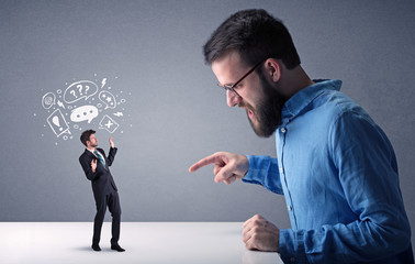 Young businessman fighting with miniature businessman