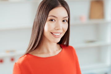 White smile. Portrait of beautiful happy young woman smiling while looking at the camera and posing on the light background