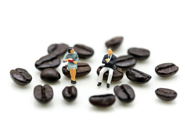 Fototapeta na wymiar Miniatures people : sitting on coffee bean using as background business concept.