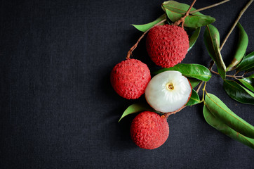 Fresh fruit Lychee on black clothing background, top view photo, copy space for text