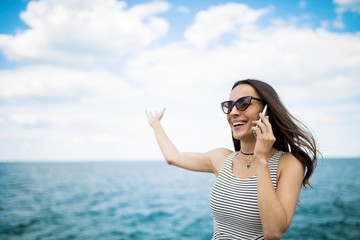 Beautiful young modern brunette woman in sunglasses talking on the phone