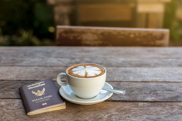 Coffee cup and Thailand passport on wooden table. business,food,beverage,drink,travel concept