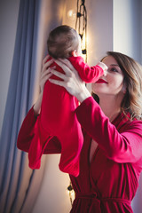 Redhead mother with new born child in red