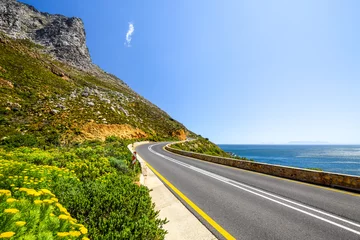 Crédence de cuisine en verre imprimé Atlantic Ocean Road Stunning view of Route 44 in the eastern part of False Bay near Cape Town between Gordon's Bay and Pringle Bay. Hottentots Holland Mountain range in the background. Beautiful flowers on the left.