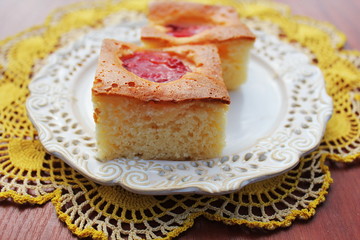Slice of fresh plums cake on white plate