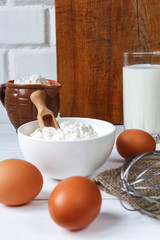 Fototapeta na wymiar eggs milk flour and various ingredients for cooking in rustic style with copy space