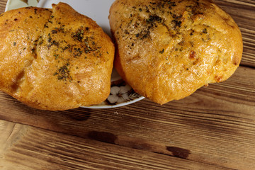 Fresh bread ciabatta on a plate on wooden table
